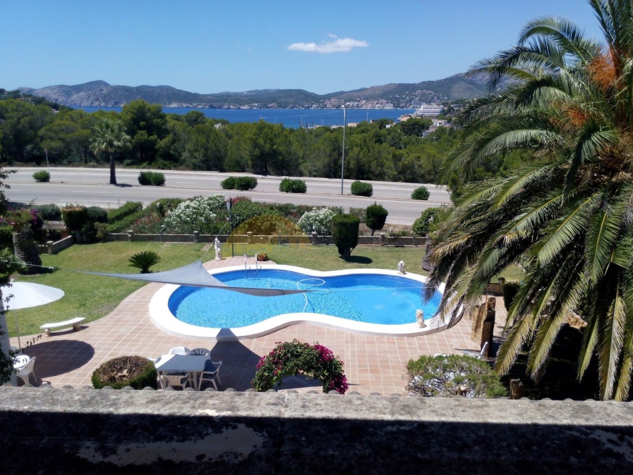 Panoramic view of the pool area with sea view and well-maintained outdoor space