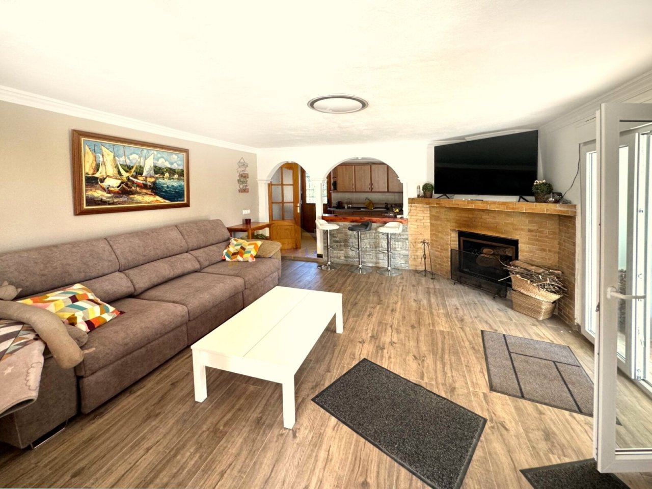 Living room with integrated fireplace, open layout, and direct access to the terrace.