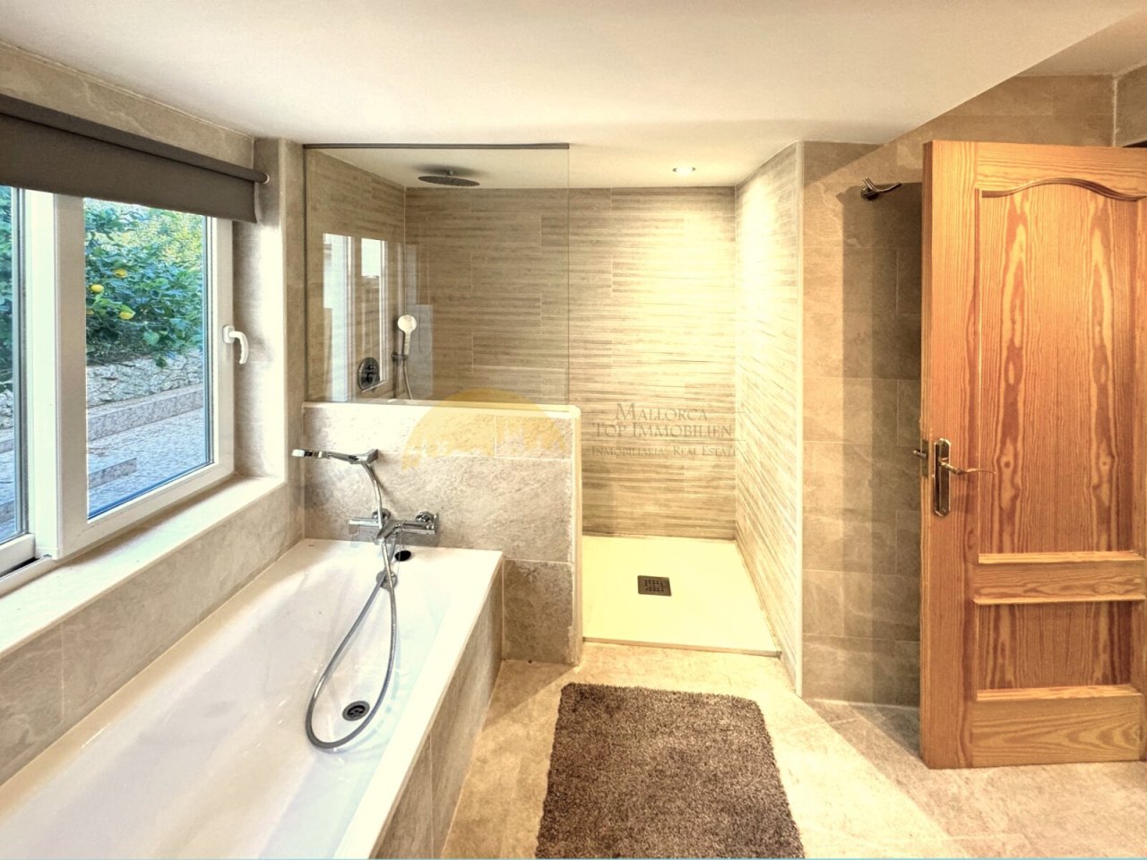 Luxurious bathroom with walk-in shower, freestanding bathtub, and large window facing the garden