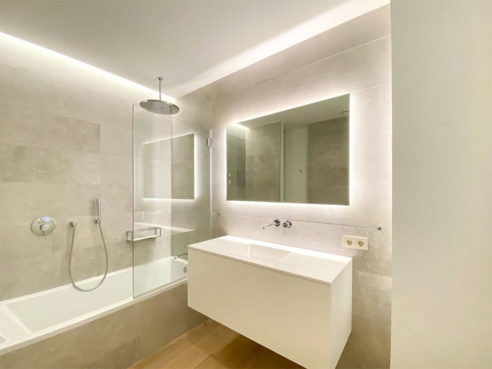 Baño moderno con ducha a ras y sistema de espejo LED Baño moderno con ducha a ras y sistema de espejo LED