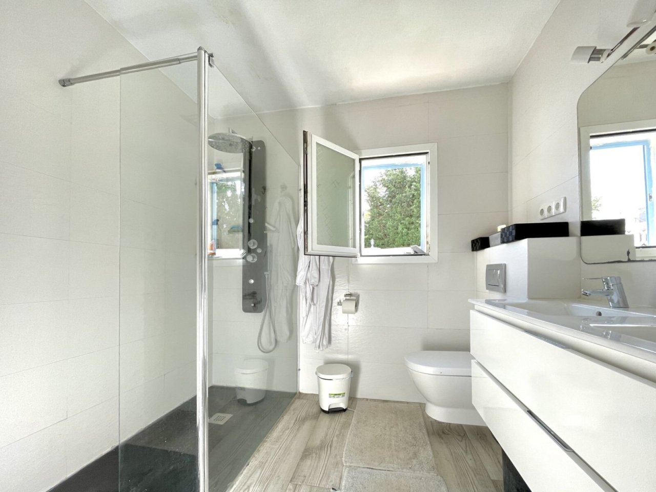 Baño moderno con ducha a nivel del suelo, lavabo doble y amplias ventanas. Baño moderno con ducha a nivel del suelo, lavabo doble y amplias ventanas.