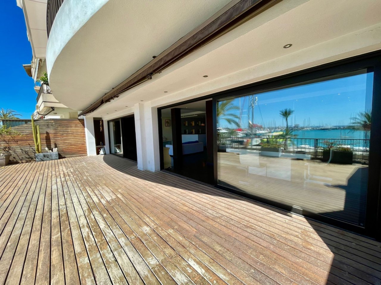 Área de terraza con elementos correderos de altura completa y panorama del puerto