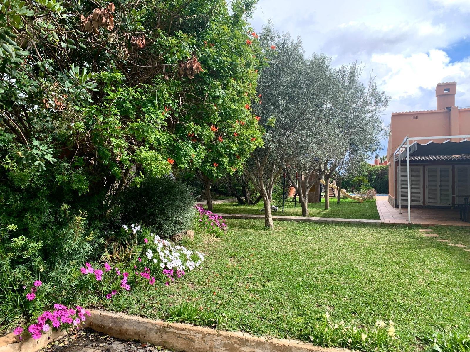 Jardín similar a un parque con árboles antiguos y áreas verdes bien cuidadas Jardín similar a un parque con árboles antiguos y áreas verdes bien cuidadas