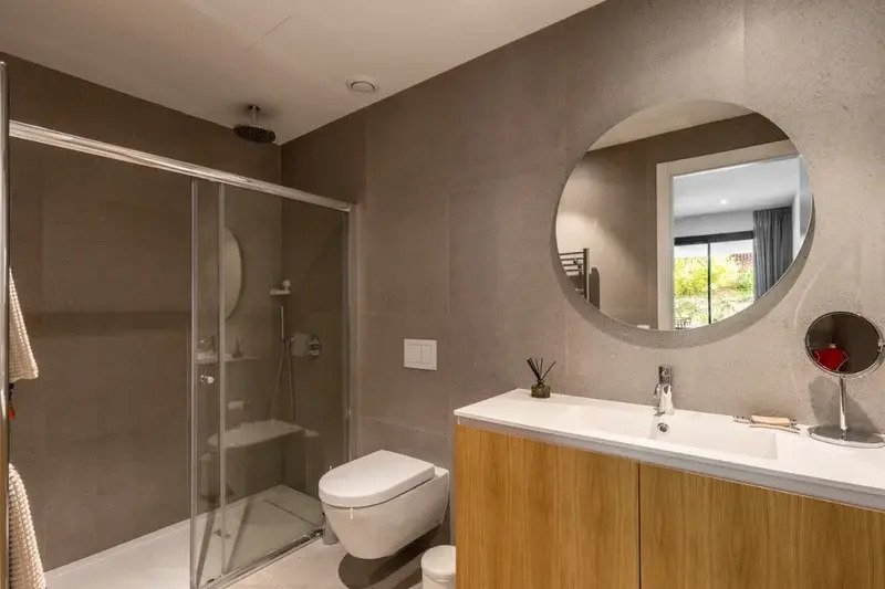 Baño moderno con ducha a ras de suelo, doble lavabo y distribución práctica del espacio Baño moderno con ducha a ras de suelo, doble lavabo y distribución práctica del espacio