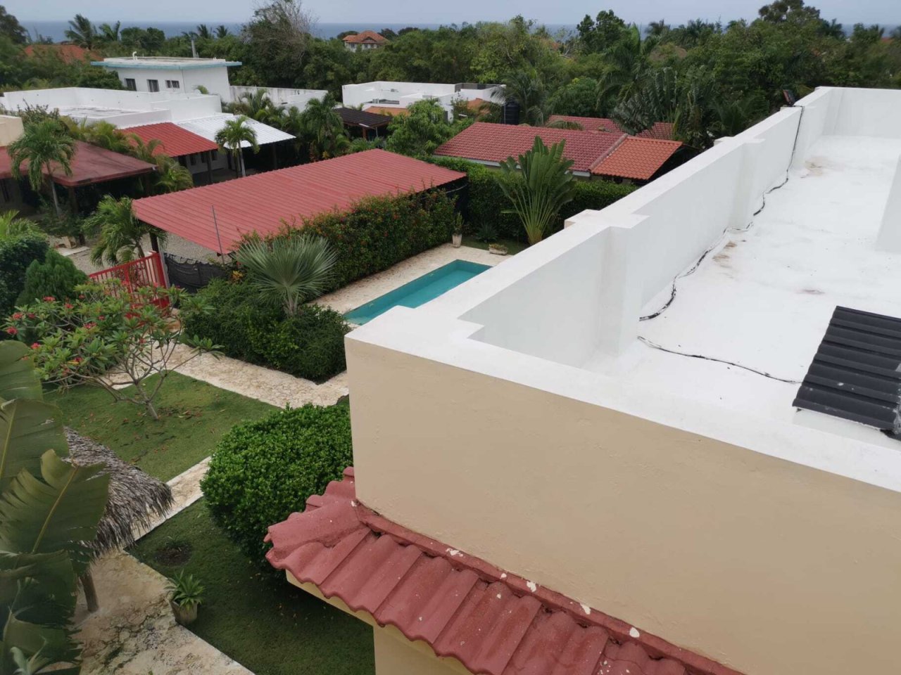 Vista aérea: Casa moderna de techo plano con amplia zona de piscina y vista estructurada del vecindario Vista aérea: Casa moderna de techo plano con amplia zona de piscina y vista estructurada del vecindario