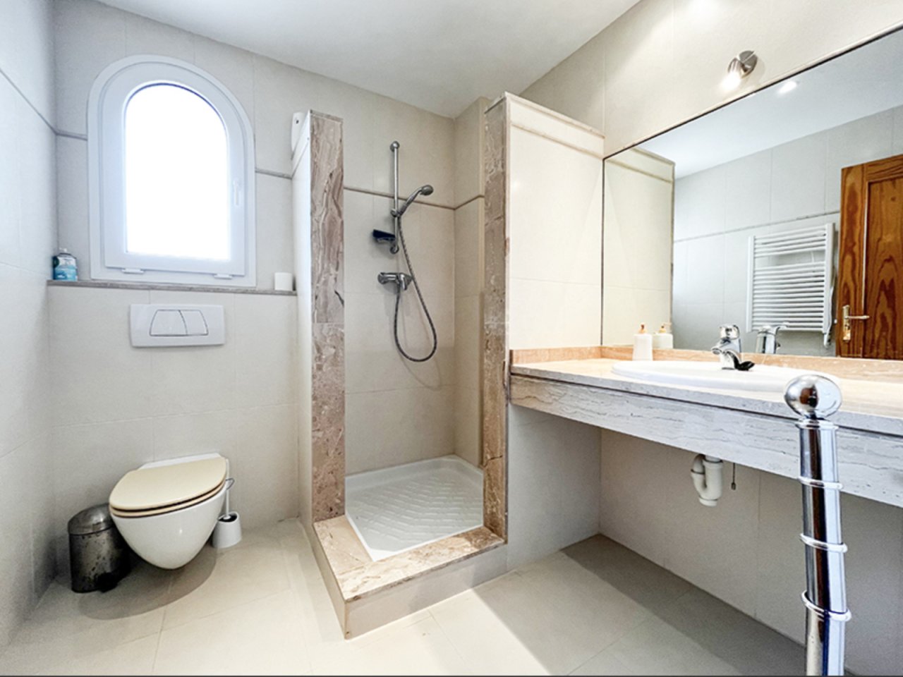 Baño moderno con ducha a ras de suelo y lavabo amplio