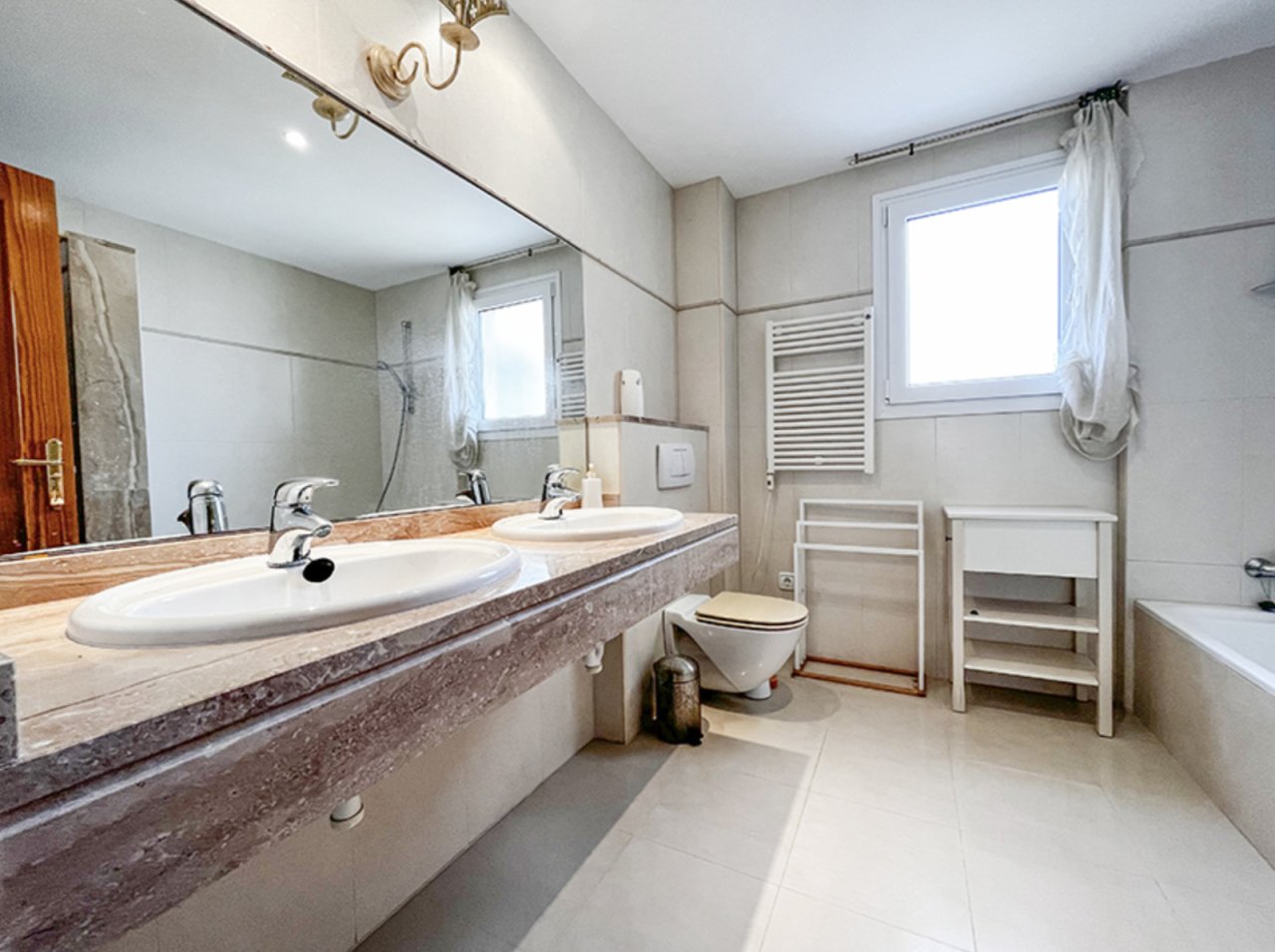 Elegante baño con doble lavabo y amplias opciones de almacenamiento