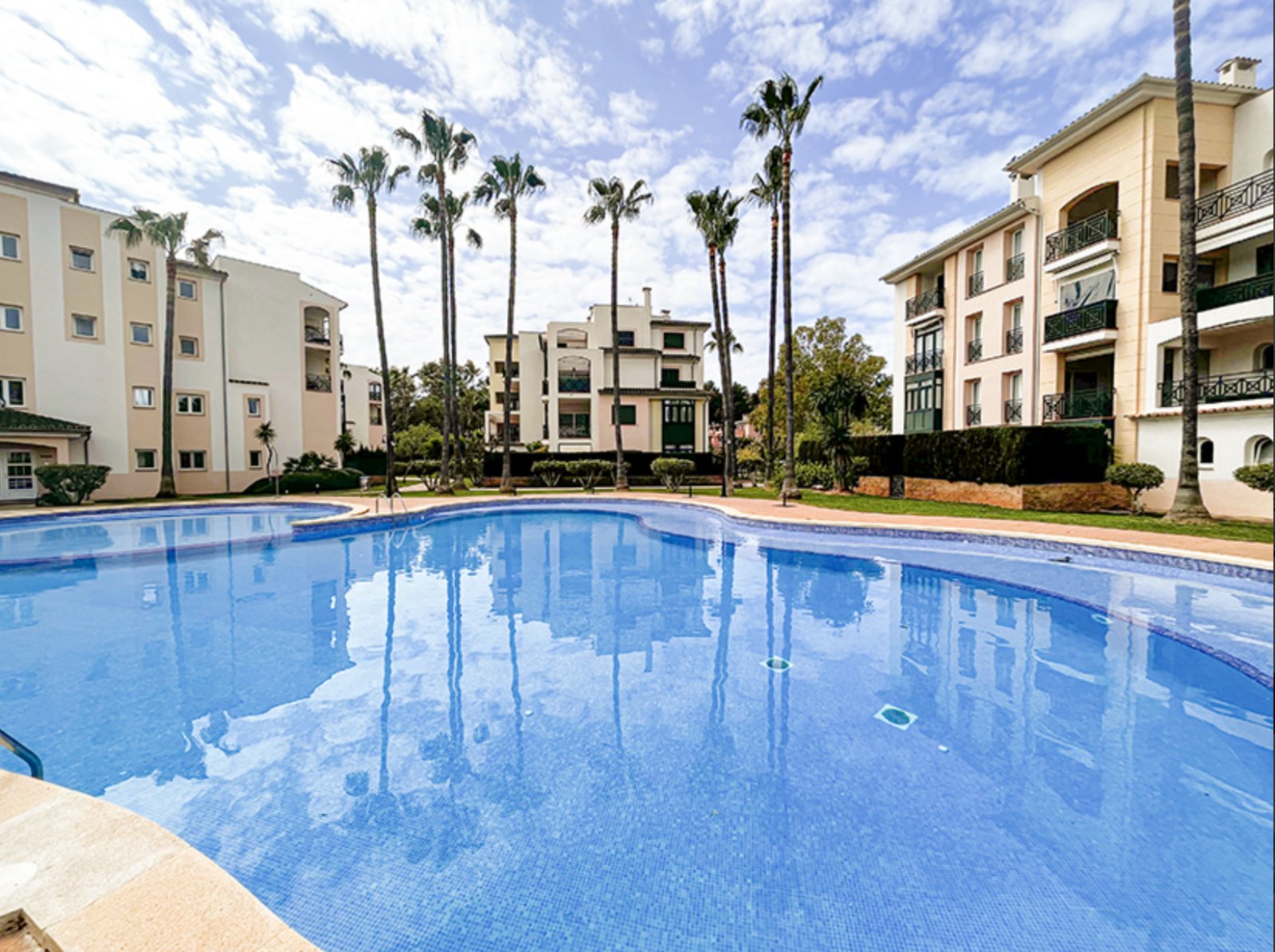 Piscina con vegetación tropical y amplio área comunitaria