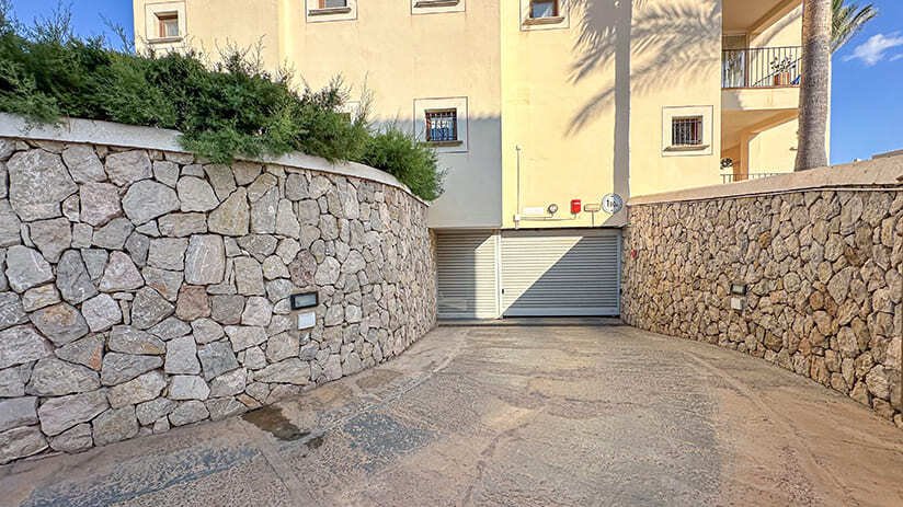 Acceso seguro con puerta automática y robustos muros de piedra natural Acceso seguro con puerta automática y robustos muros de piedra natural