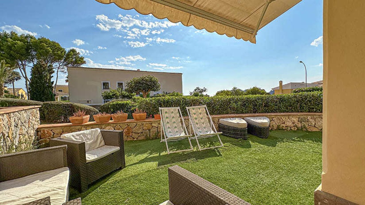 Área de terraza con pérgola integrada y amplio jardín de césped Área de terraza con pérgola integrada y amplio jardín de césped