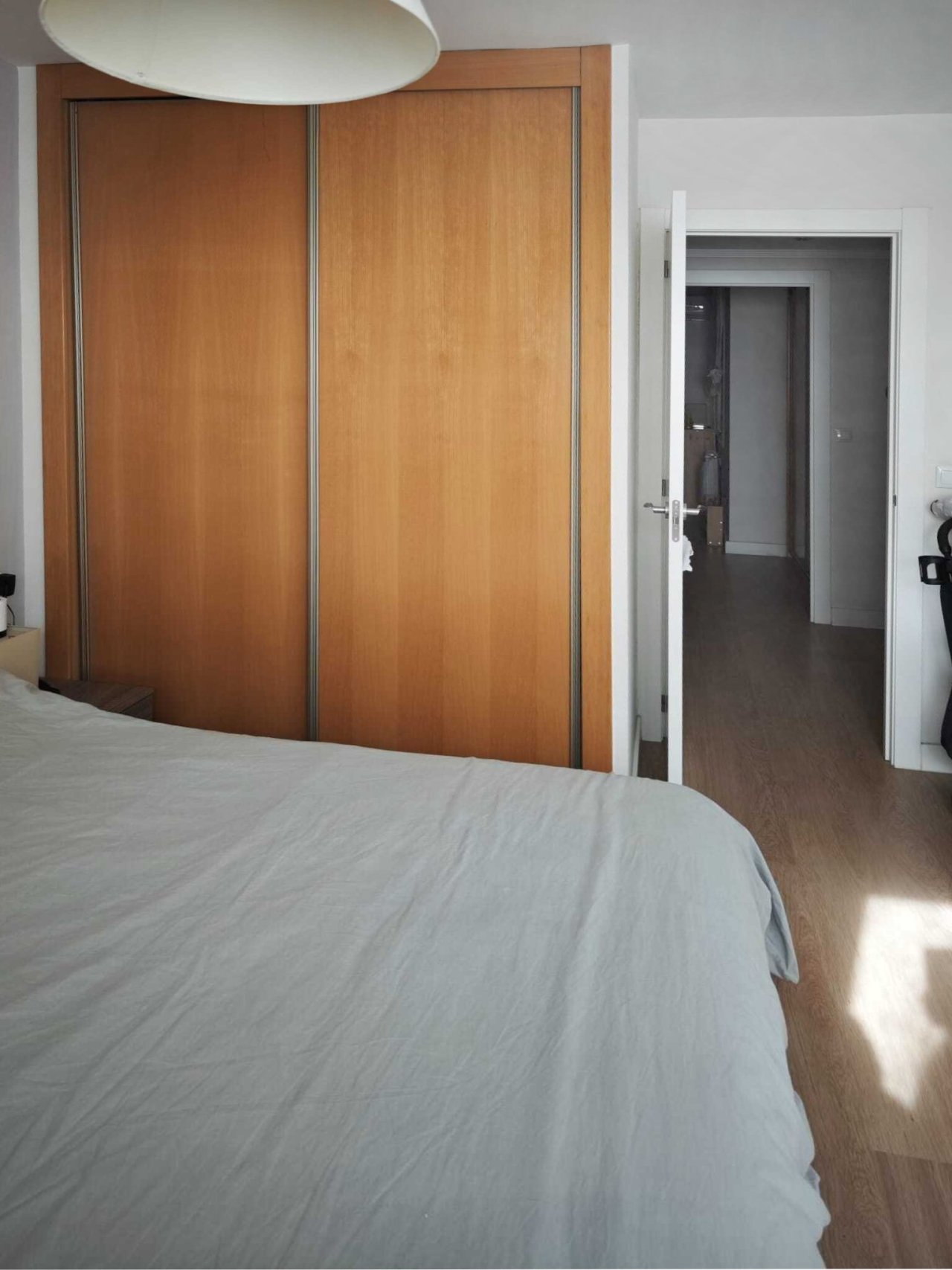 Dormitorio con puertas correderas de suelo a techo y acceso directo al baño