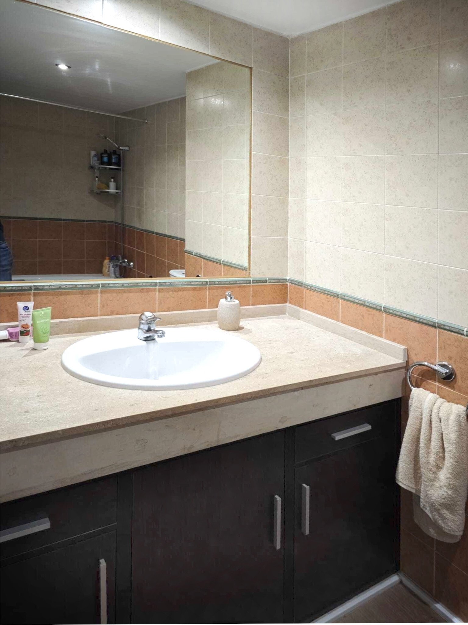 Baño moderno con gran espejo y accesorios sanitarios de alta calidad
