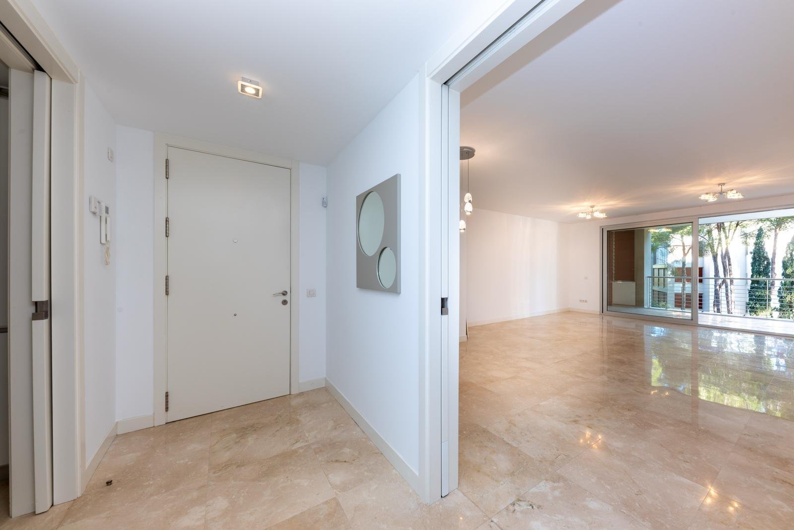 Entrada luminosa con acceso directo a la zona de estar y grandes puertas correderas de cristal Entrada luminosa con acceso directo a la zona de estar y grandes puertas correderas de cristal