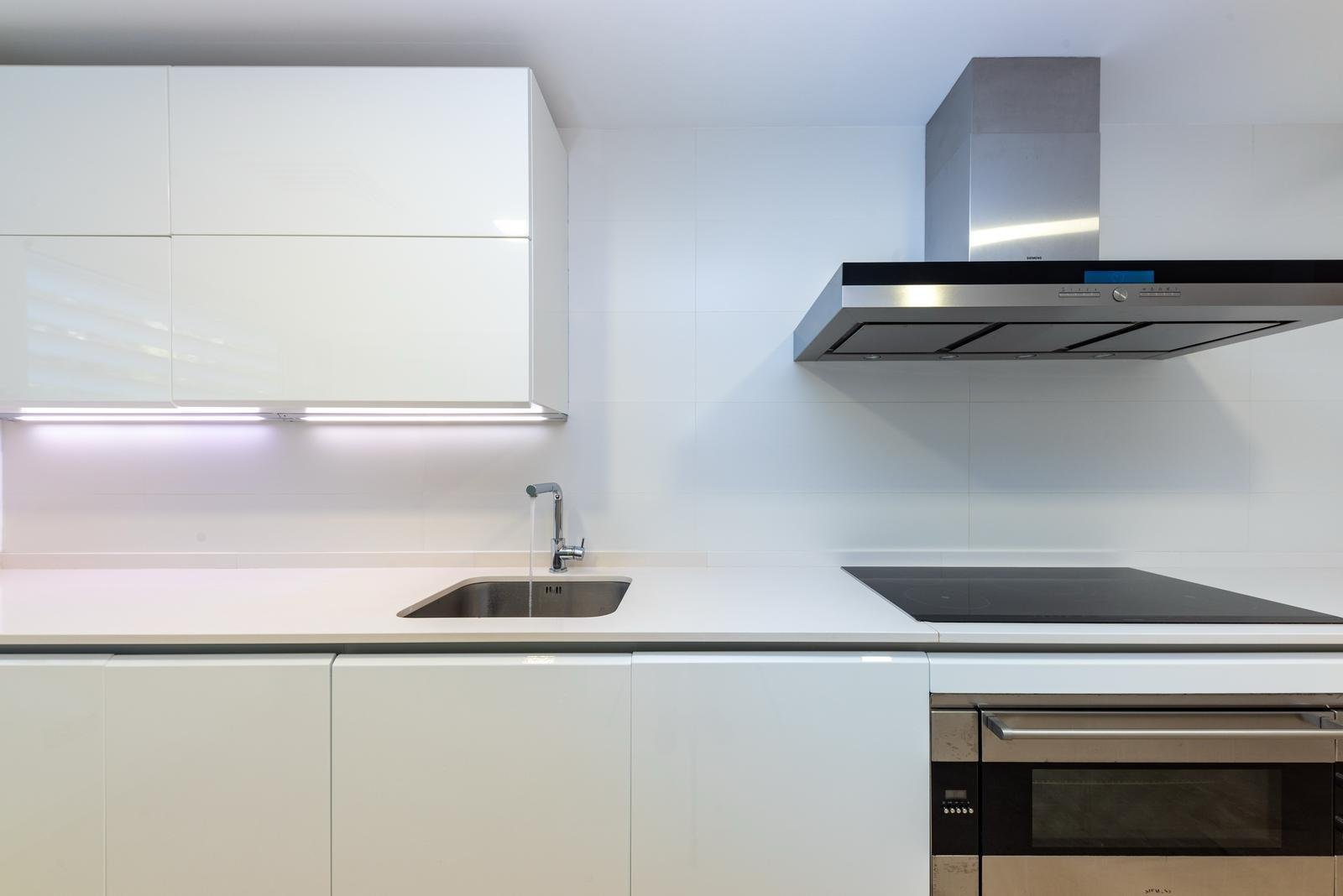 Cocina moderna con fregadero integrado, campana extractora de alta calidad y flujo de trabajo bien pensado Cocina moderna con fregadero integrado, campana extractora de alta calidad y flujo de trabajo bien pensado