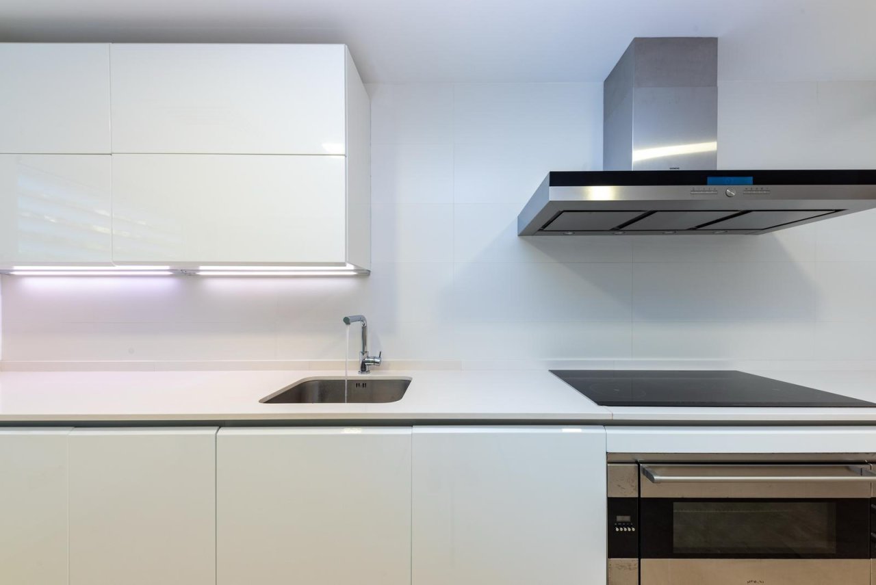Cocina moderna con fregadero integrado, campana extractora de alta calidad y flujo de trabajo bien pensado Cocina moderna con fregadero integrado, campana extractora de alta calidad y flujo de trabajo bien pensado