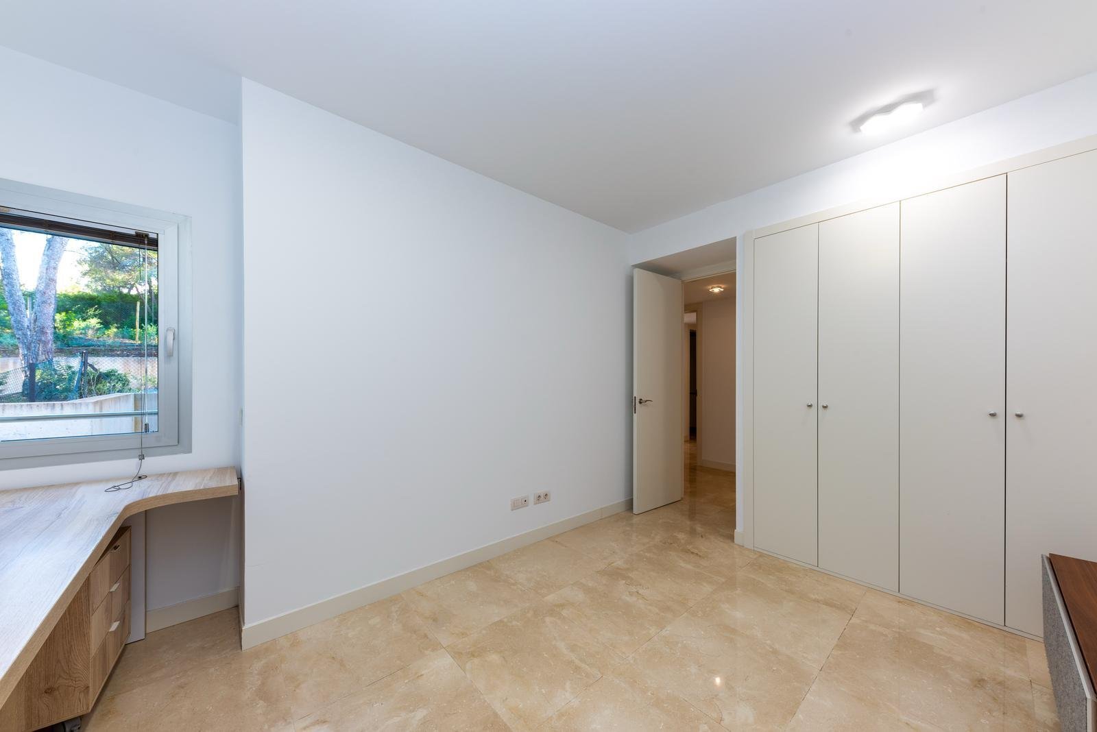Amplia habitación con armarios empotrados a medida y espacio de trabajo junto a la ventana Amplia habitación con armarios empotrados a medida y espacio de trabajo junto a la ventana