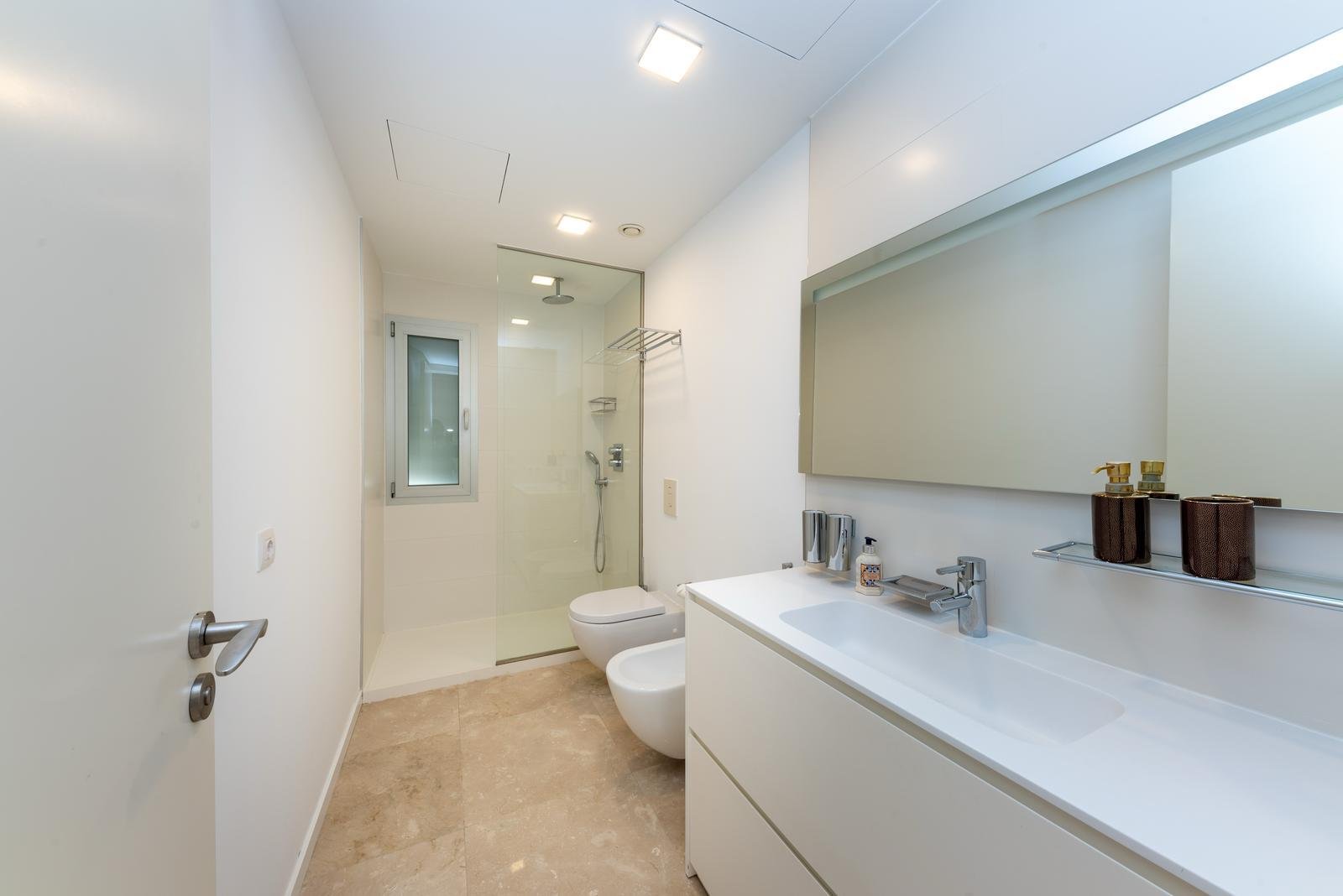 Baño moderno con ducha a ras de suelo, doble lavabo e integración inteligente de almacenamiento Baño moderno con ducha a ras de suelo, doble lavabo e integración inteligente de almacenamiento