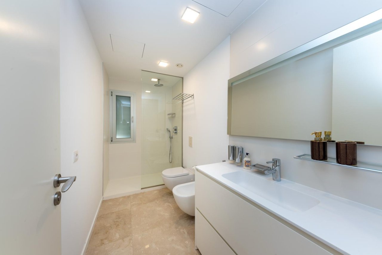 Baño moderno con ducha a ras de suelo, doble lavabo e integración inteligente de almacenamiento Baño moderno con ducha a ras de suelo, doble lavabo e integración inteligente de almacenamiento