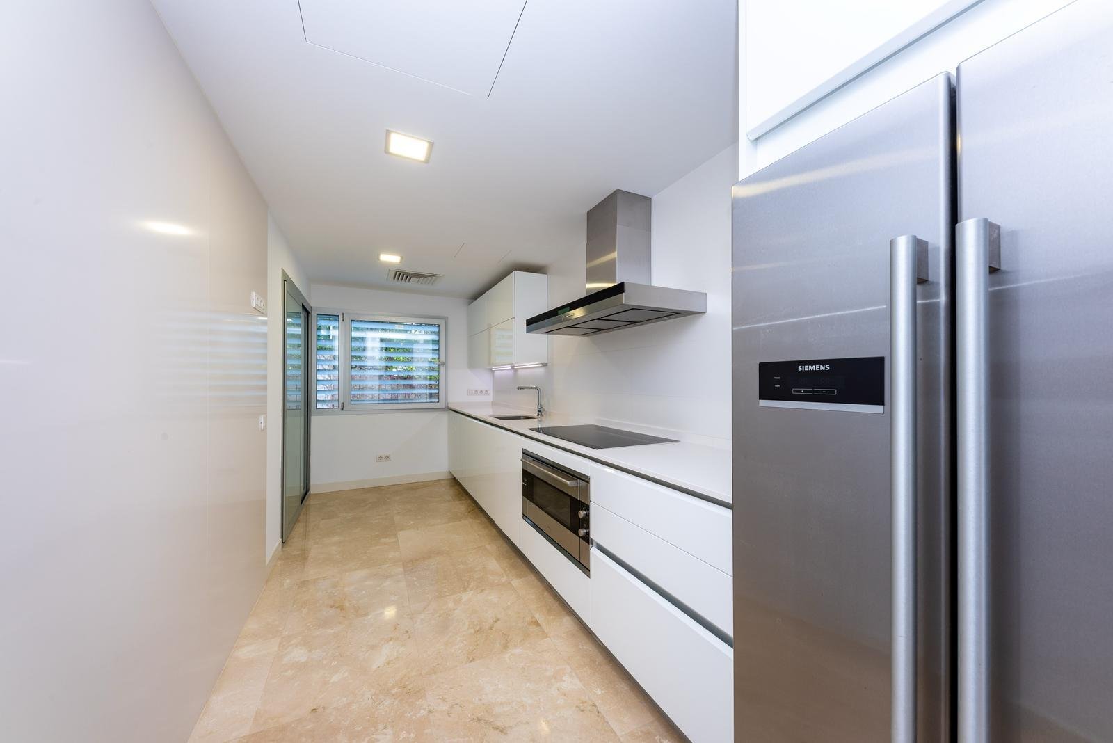 Cocina moderna con electrodomésticos de alta gama y zona de trabajo eficiente Cocina moderna con electrodomésticos de alta gama y zona de trabajo eficiente