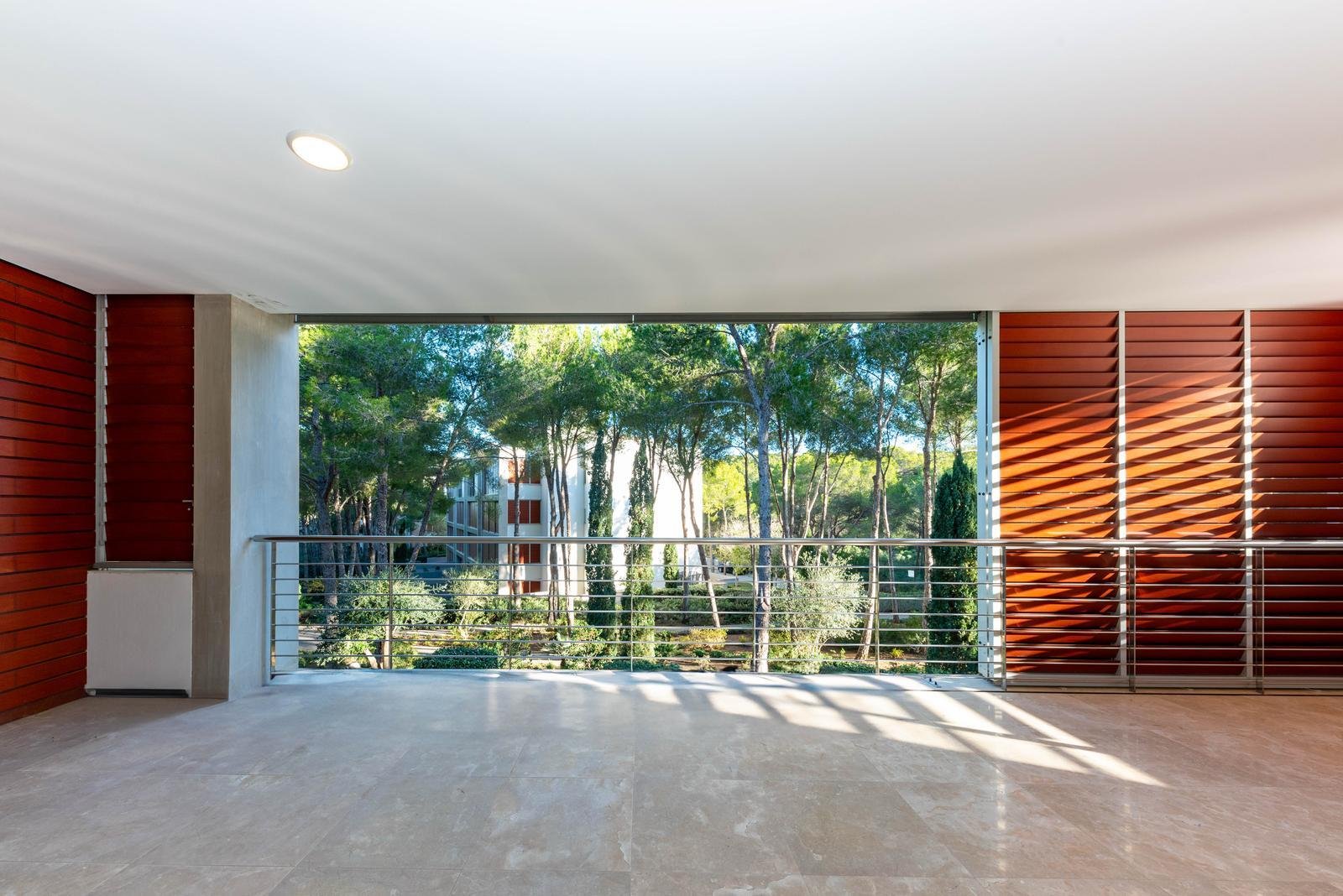 Área habitable abierta con puertas correderas de cristal panorámicas y vista al bosque Área habitable abierta con puertas correderas de cristal panorámicas y vista al bosque