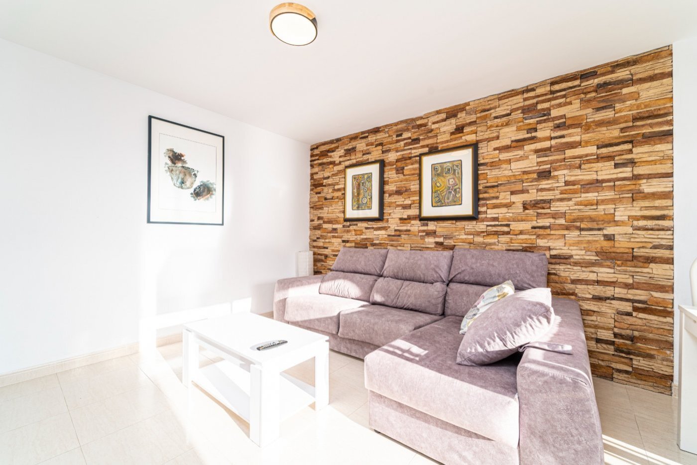 Zona de estar con una pared de acento de madera con carácter y una distribución de espacio bien pensada Zona de estar con una pared de acento de madera con carácter y una distribución de espacio bien pensada