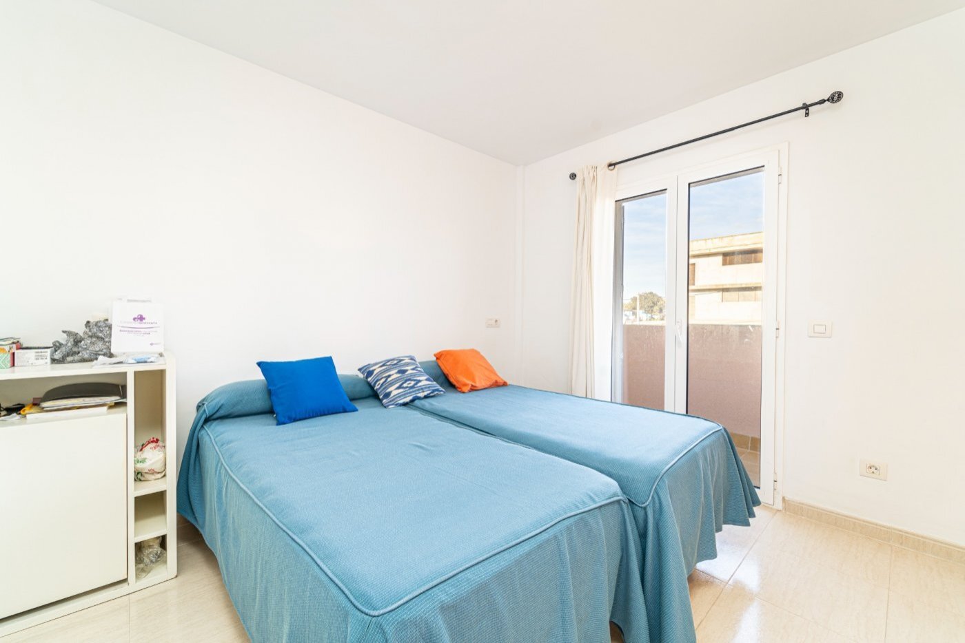 Dormitorio luminoso con puertas al balcón y almacenamiento práctico Dormitorio luminoso con puertas al balcón y almacenamiento práctico