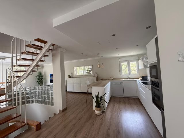 Cocina moderna con distribución inteligente del espacio e integración sin fisuras en la zona de estar Cocina moderna con distribución inteligente del espacio e integración sin fisuras en la zona de estar