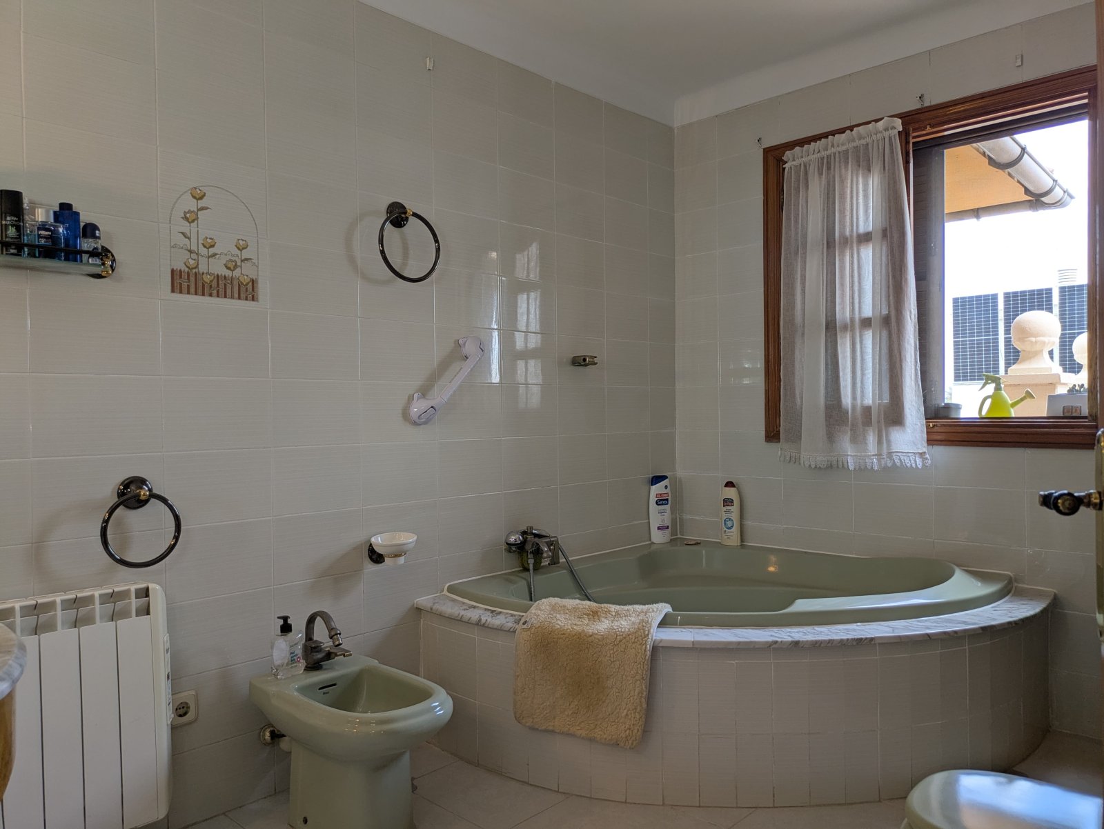 Baño de bienestar con bañera en esquina y diseño de azulejos de gran superficie