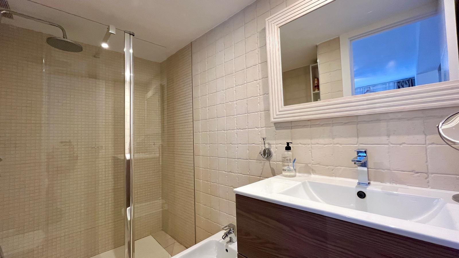 Baño moderno con ducha a ras de suelo, doble lavabo y armario espejo de gran tamaño Baño moderno con ducha a ras de suelo, doble lavabo y armario espejo de gran tamaño