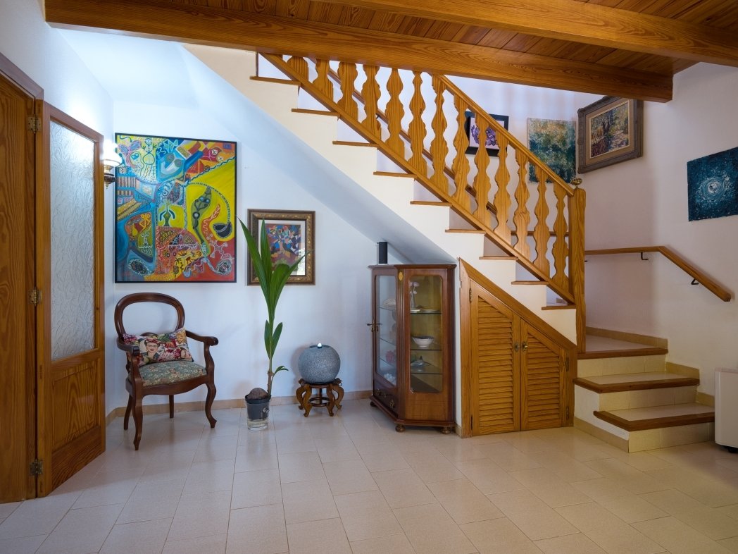 Vestíbulo representativo con elegante escalera de madera y distribución abierta del espacio Vestíbulo representativo con elegante escalera de madera y distribución abierta del espacio