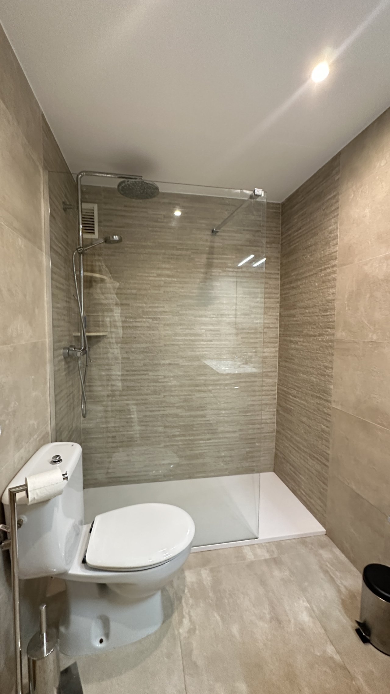 Baño moderno con ducha a nivel del suelo, mampara de cristal y iluminación óptima Baño moderno con ducha a nivel del suelo, mampara de cristal y iluminación óptima