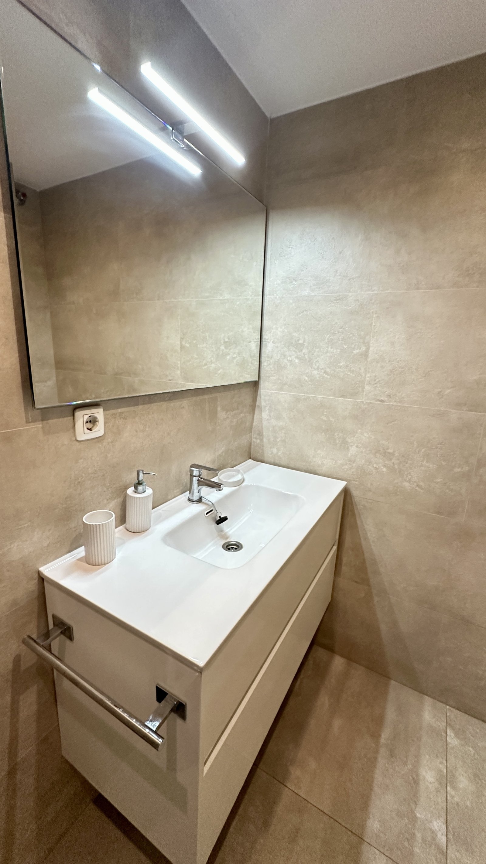 Baño moderno para huéspedes con luces LED en el espejo y equipamiento sanitario de alta calidad Baño moderno para huéspedes con luces LED en el espejo y equipamiento sanitario de alta calidad