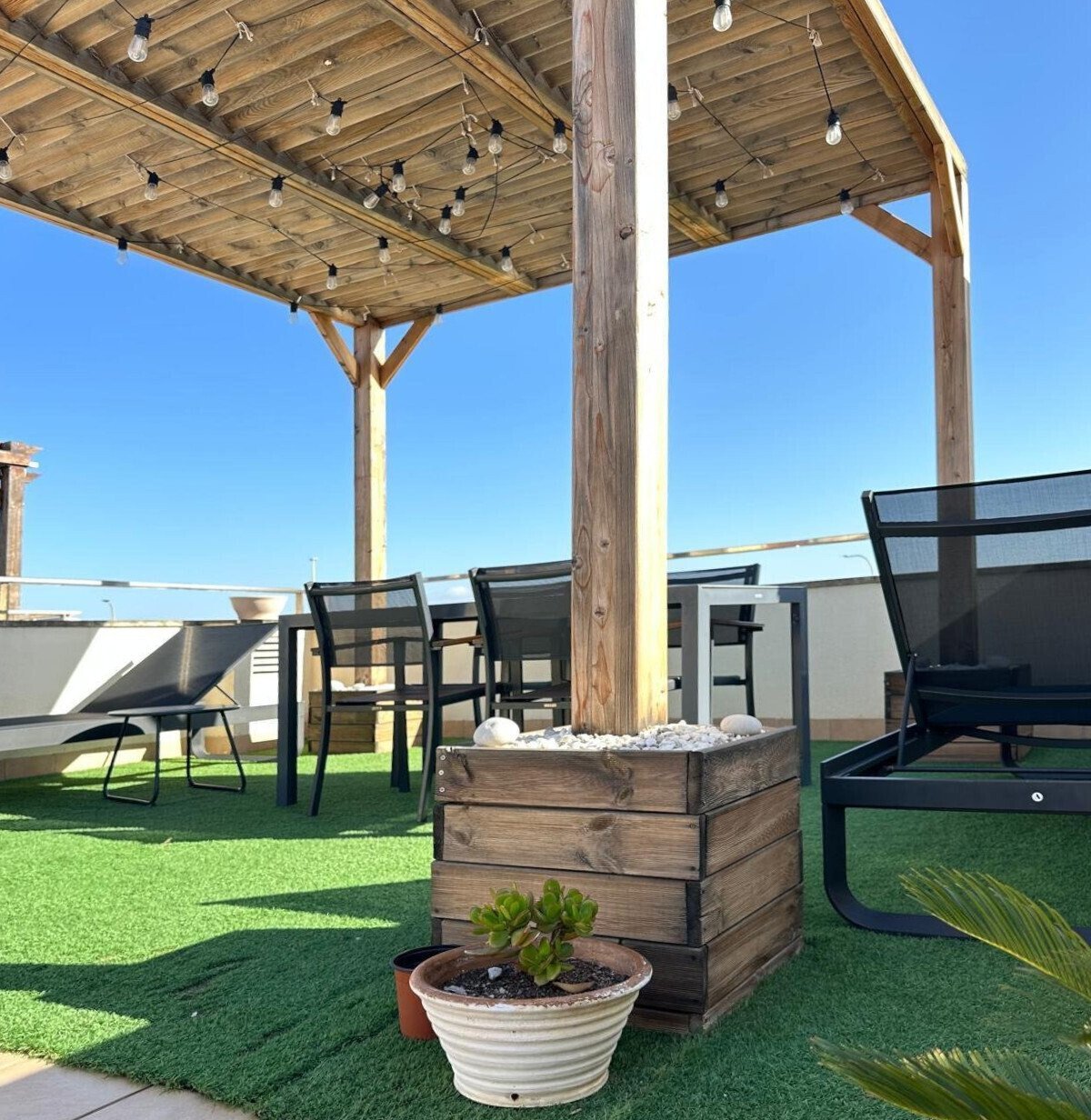 Terraza en la azotea con pérgola de alta calidad y chimenea integrada Terraza en la azotea con pérgola de alta calidad y chimenea integrada