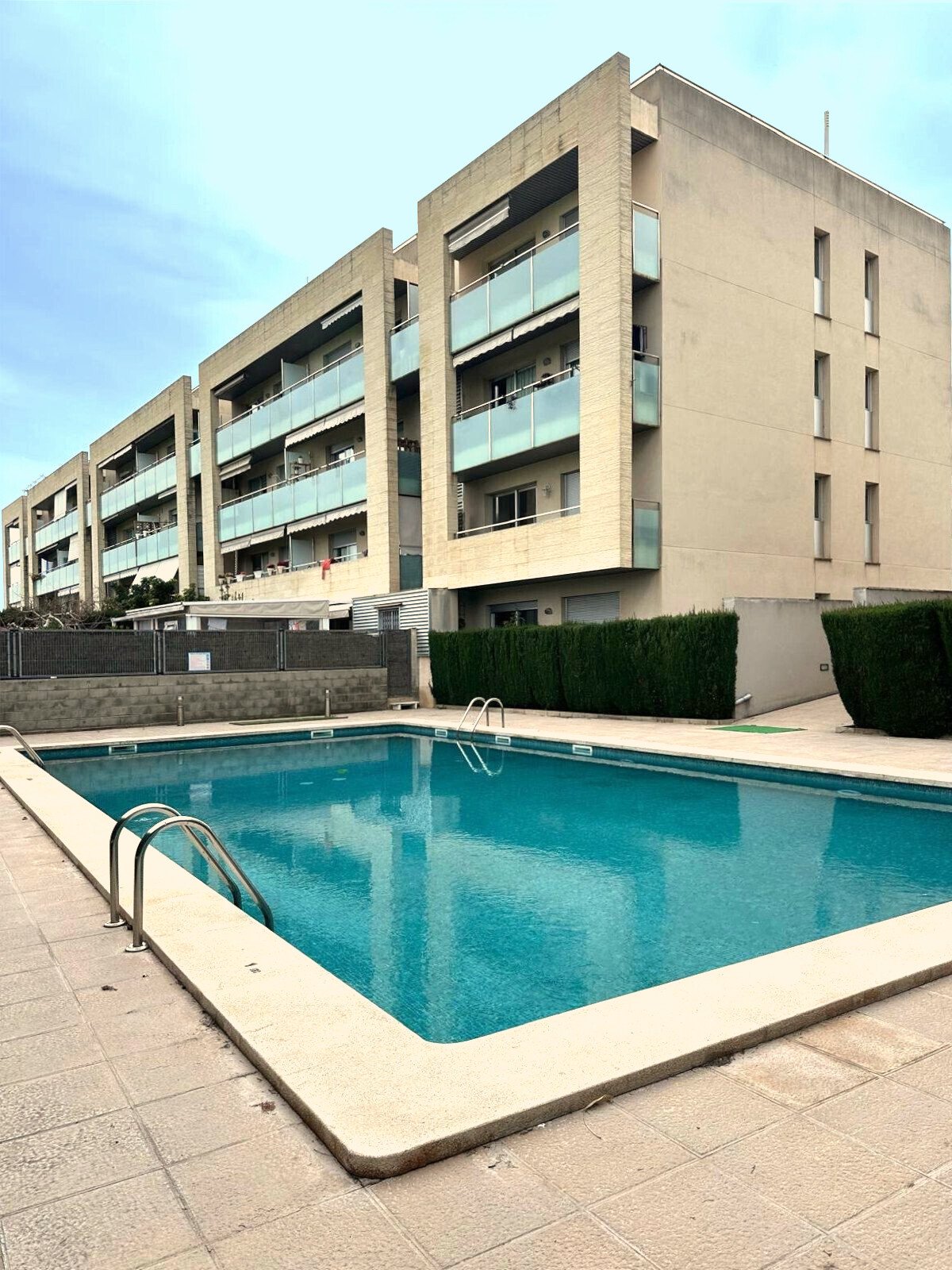 Piscina comunitaria con diseño moderno y áreas exteriores bien cuidadas Piscina comunitaria con diseño moderno y áreas exteriores bien cuidadas