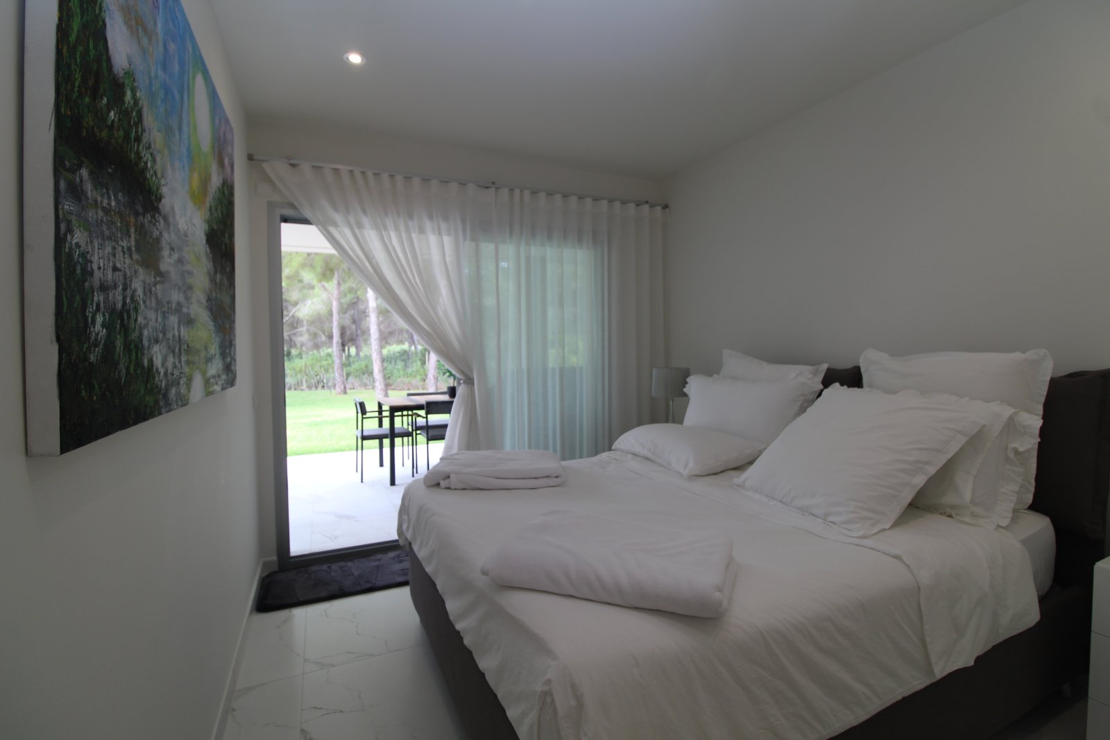 Dormitorio principal con transición fluida a la terraza y puertas correderas de gran tamaño