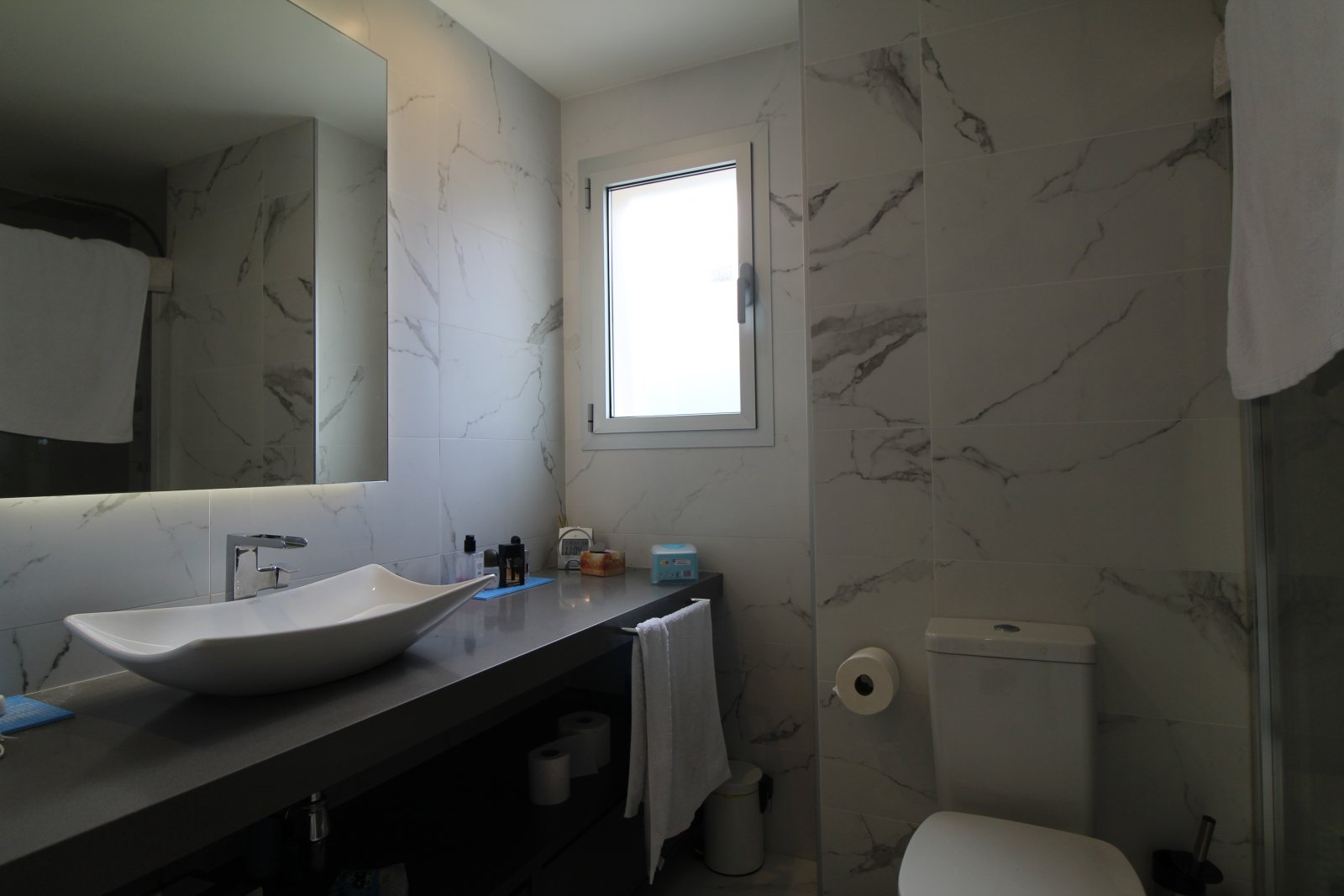 Baño moderno para invitados con aspecto de mármol y ducha a nivel del suelo