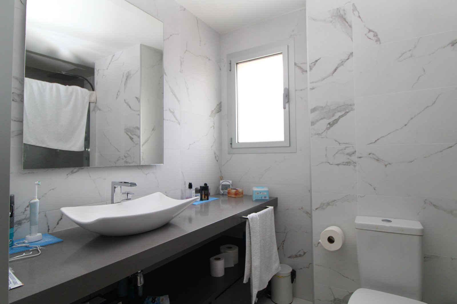 Baño moderno con revestimiento de paredes de mármol y accesorios sanitarios de alta calidad
