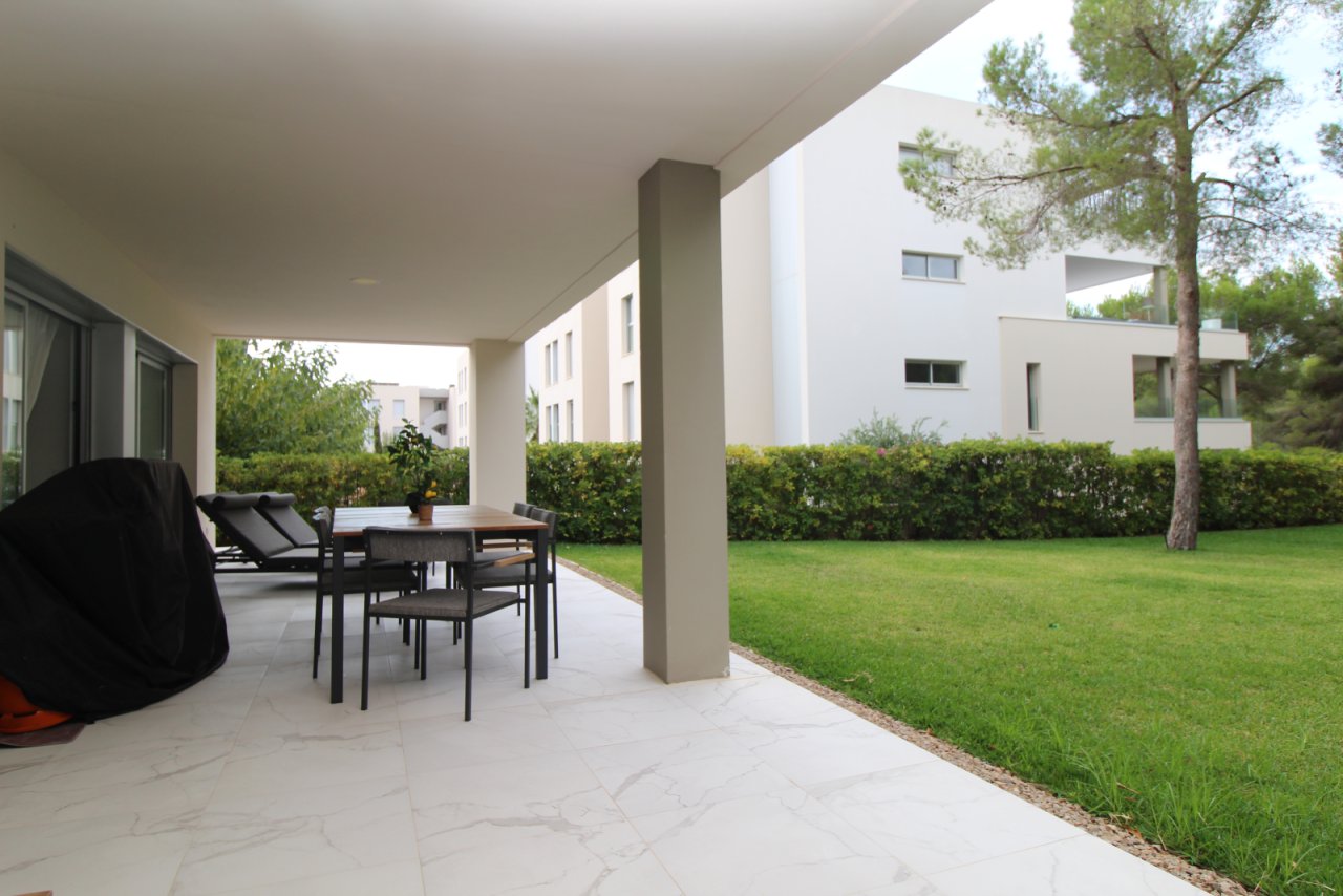 Terraza cubierta con elegantes columnas y acceso directo al jardín privado