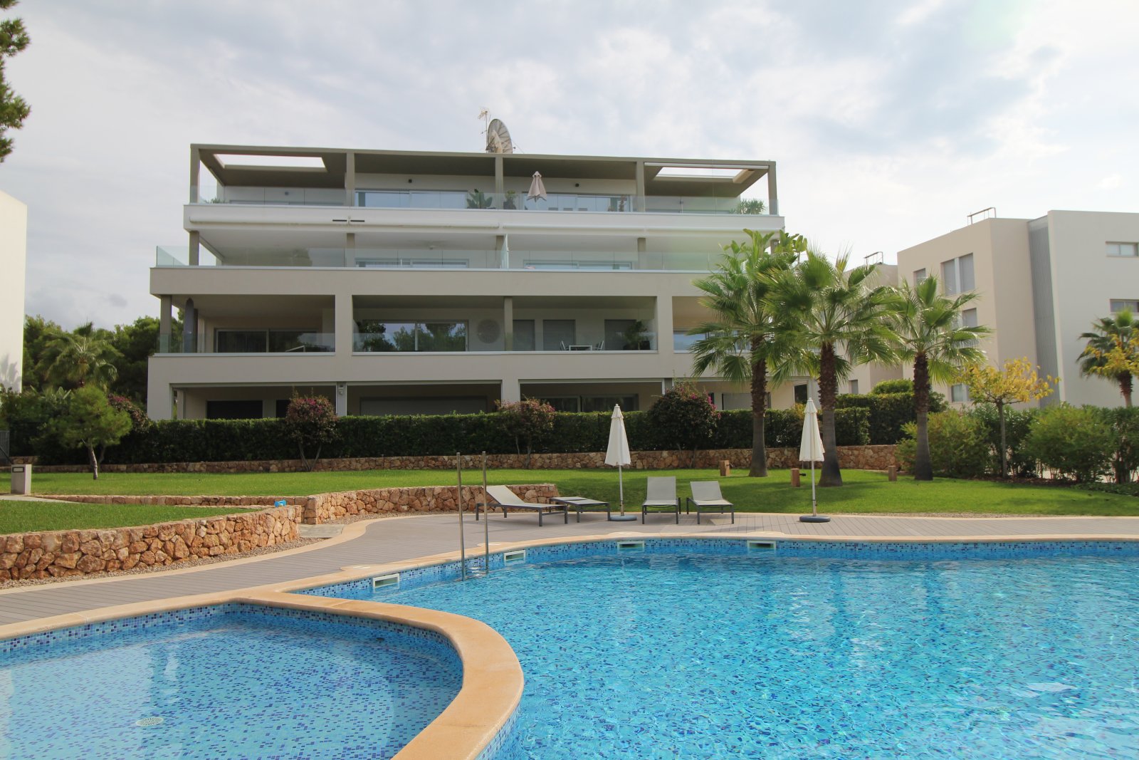 Complejo residencial moderno con piscina exclusiva y jardines bien cuidados