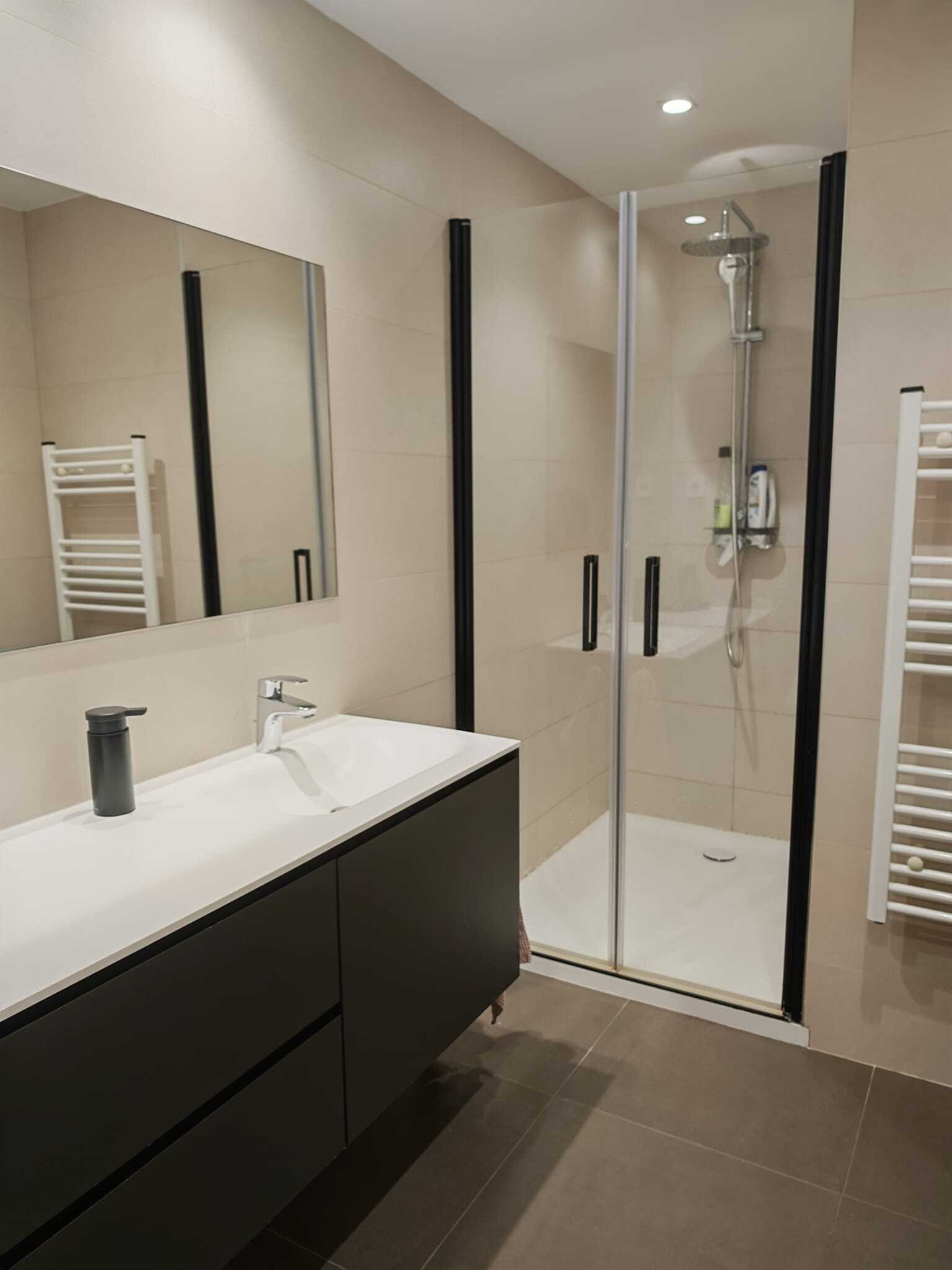 Baño moderno con ducha a nivel del suelo, doble lavabo y espejo de gran tamaño Baño moderno con ducha a nivel del suelo, doble lavabo y espejo de gran tamaño