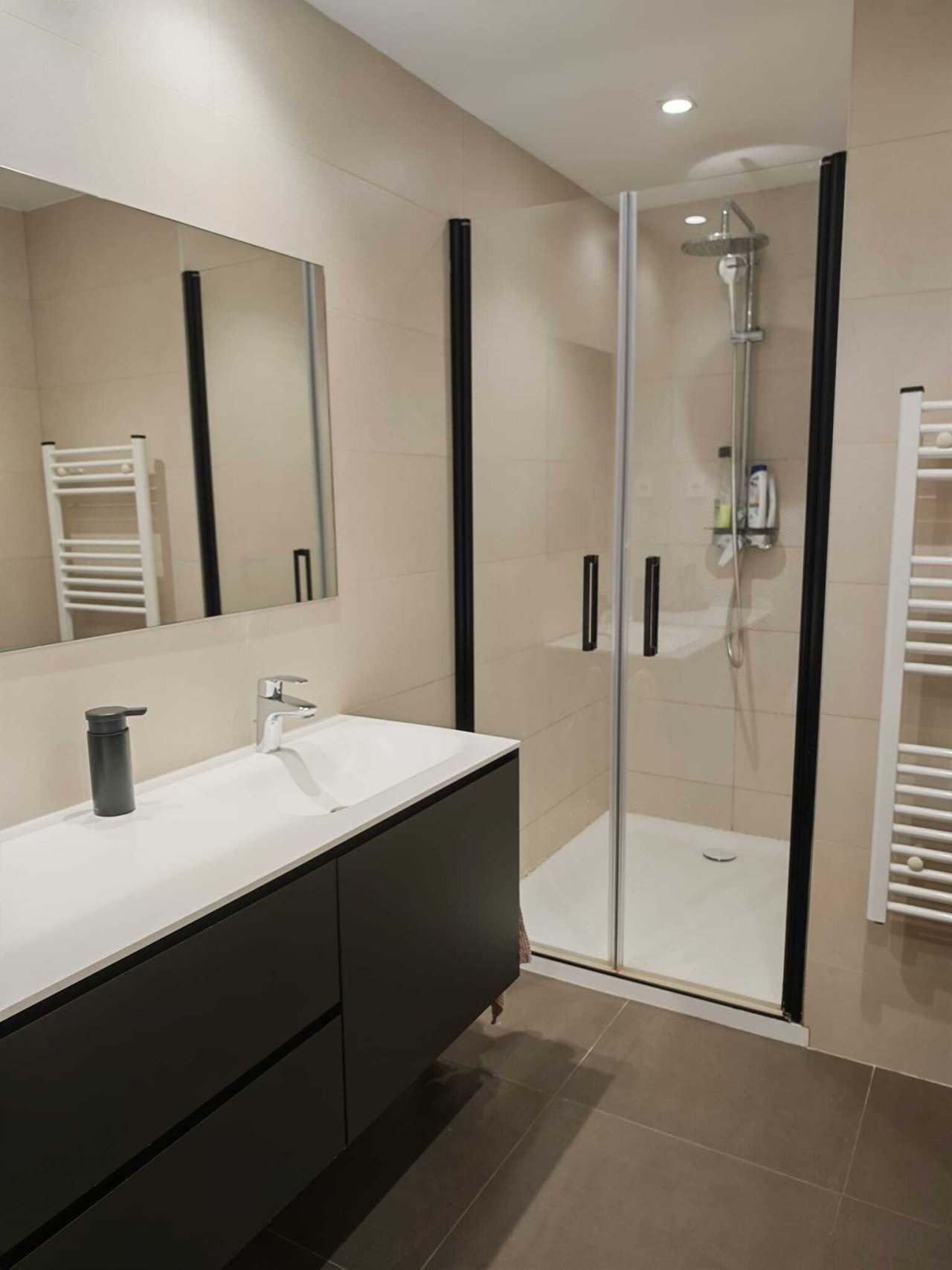 Baño moderno con ducha a nivel del suelo, doble lavabo y espejo de gran tamaño Baño moderno con ducha a nivel del suelo, doble lavabo y espejo de gran tamaño