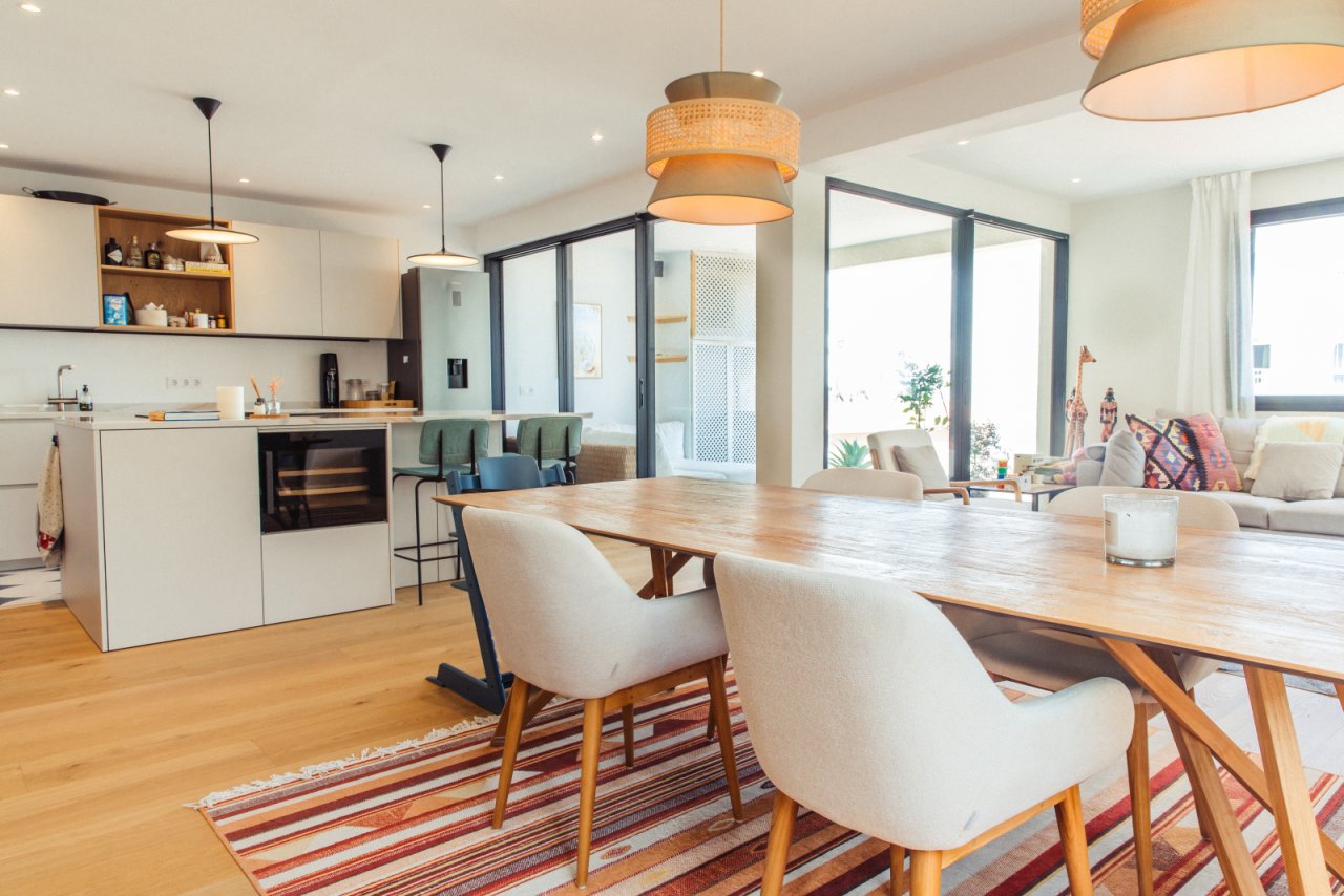 Cocina abierta con bloque de cocina bien pensado y ventanas de gran tamaño para máxima luminosidad
