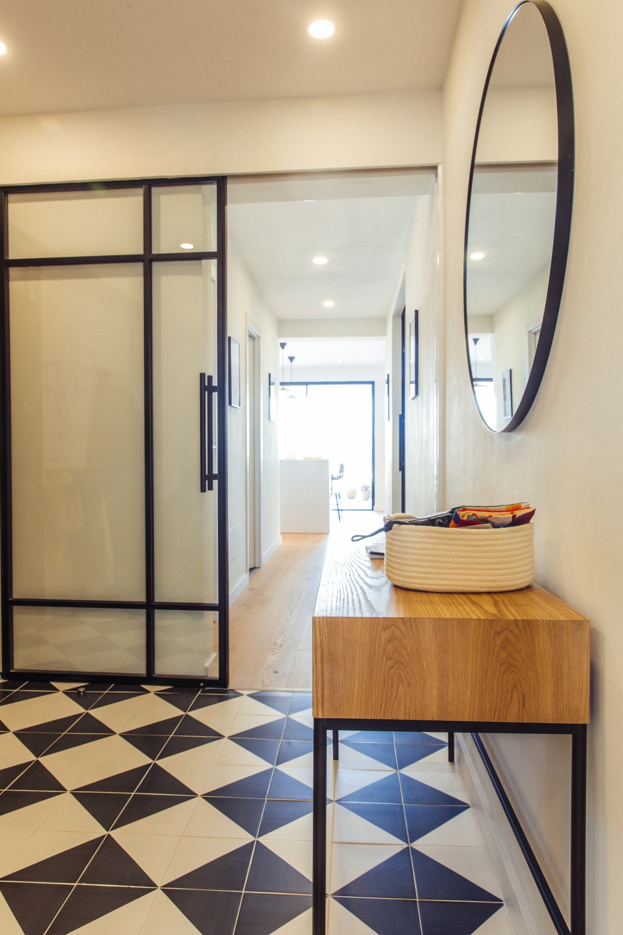 Elegante entrada con puerta corredera de suelo a techo y planificación de iluminación profesional