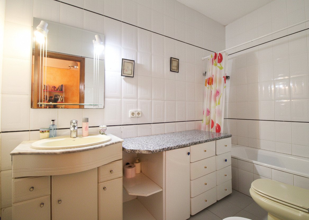 Baño elegante con doble lavabo, espejo de gran tamaño y amplia integración de almacenamiento