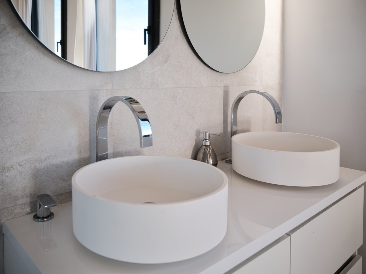 Elegante doble lavabo con grifería de alta calidad y grandes espejos