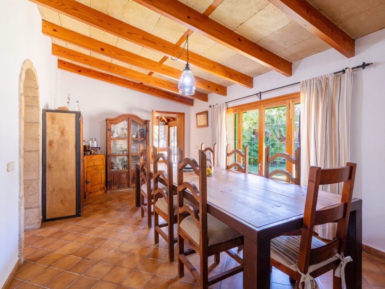 Área de comedor con vigas de madera imponentes y acceso directo a la terraza