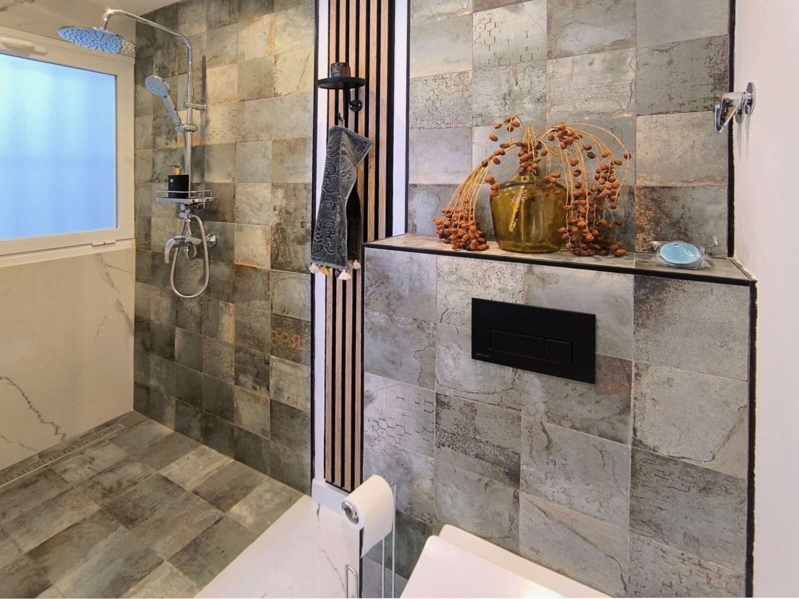 Baño lujoso con ducha a nivel del suelo, revestimiento de piedra natural y nicho integrado Baño lujoso con ducha a nivel del suelo, revestimiento de piedra natural y nicho integrado