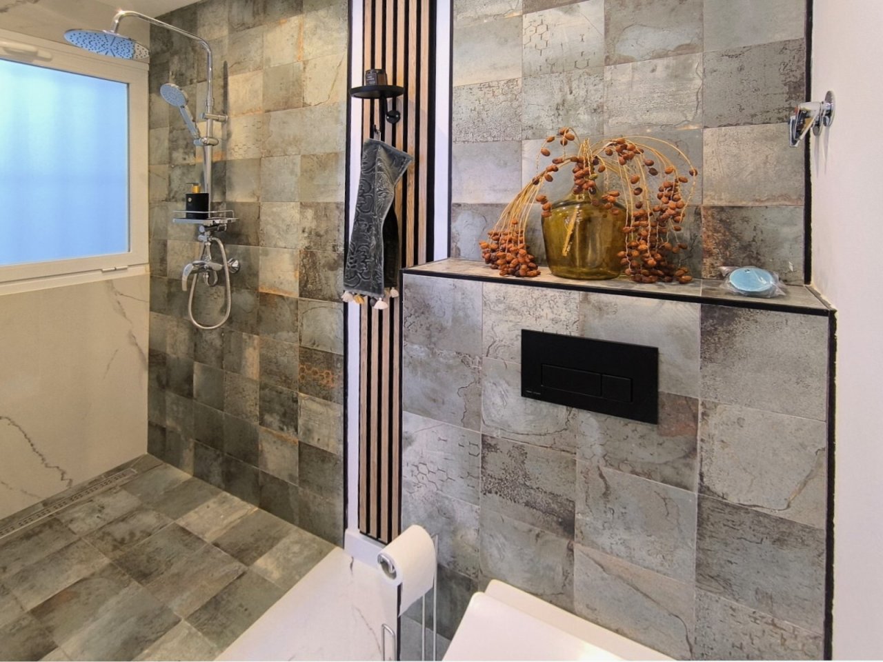 Baño lujoso con ducha a nivel del suelo, revestimiento de piedra natural y nicho integrado Baño lujoso con ducha a nivel del suelo, revestimiento de piedra natural y nicho integrado