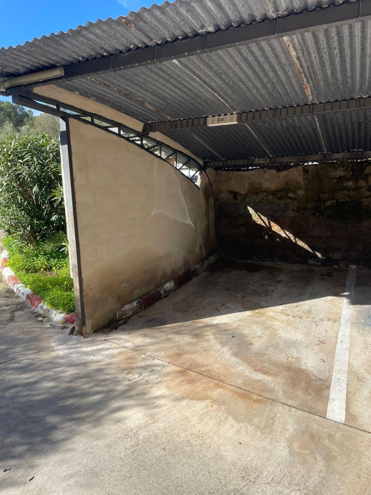 Carport con techado resistente y superficie de estacionamiento sellada