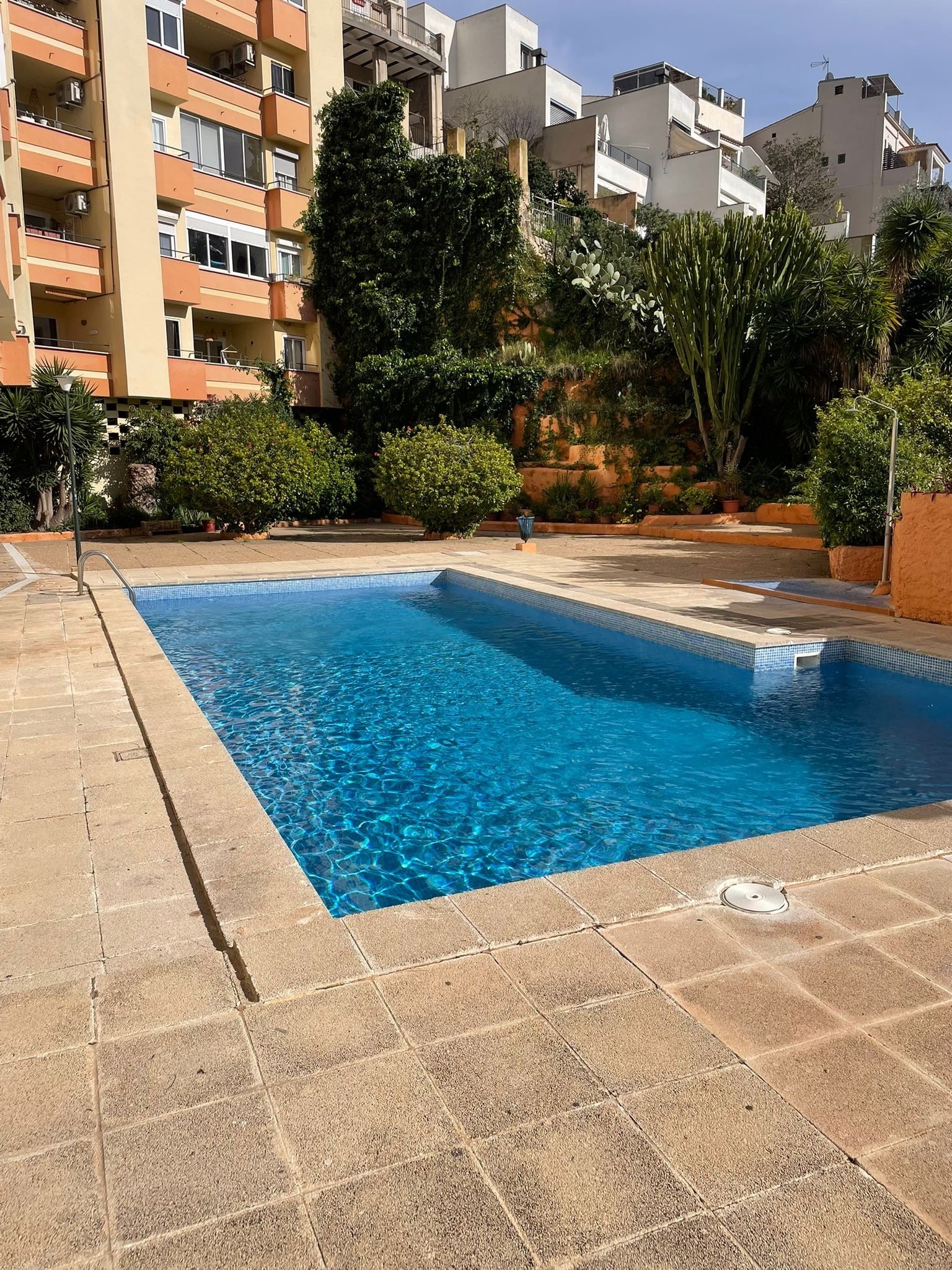 Oasis de refresco con una piscina de gran tamaño y una zona de ocio soleada